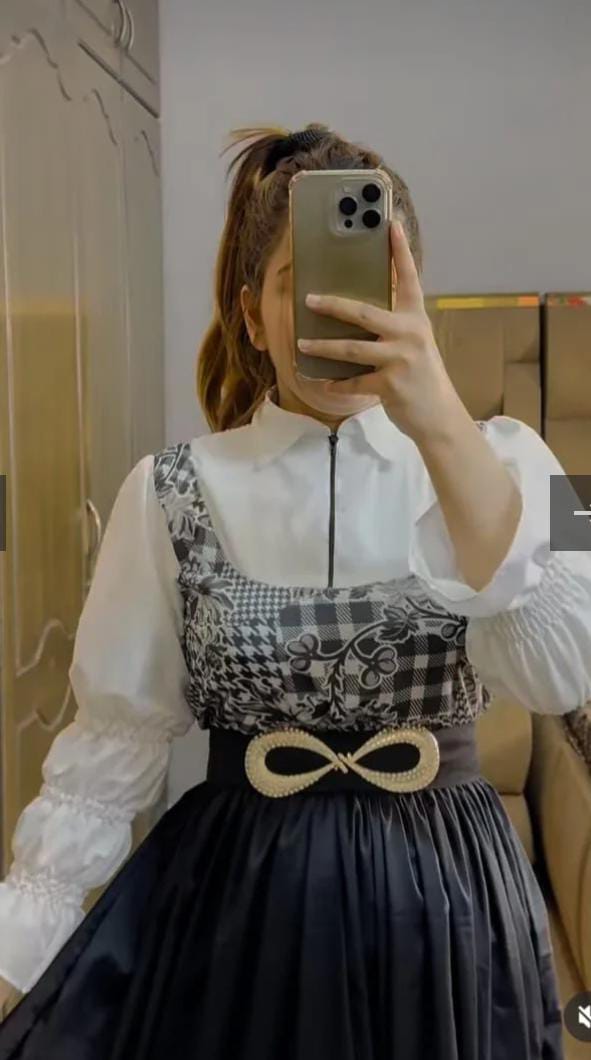 Close-up of checkered top and flowy black skirt – fashion outfit for women
